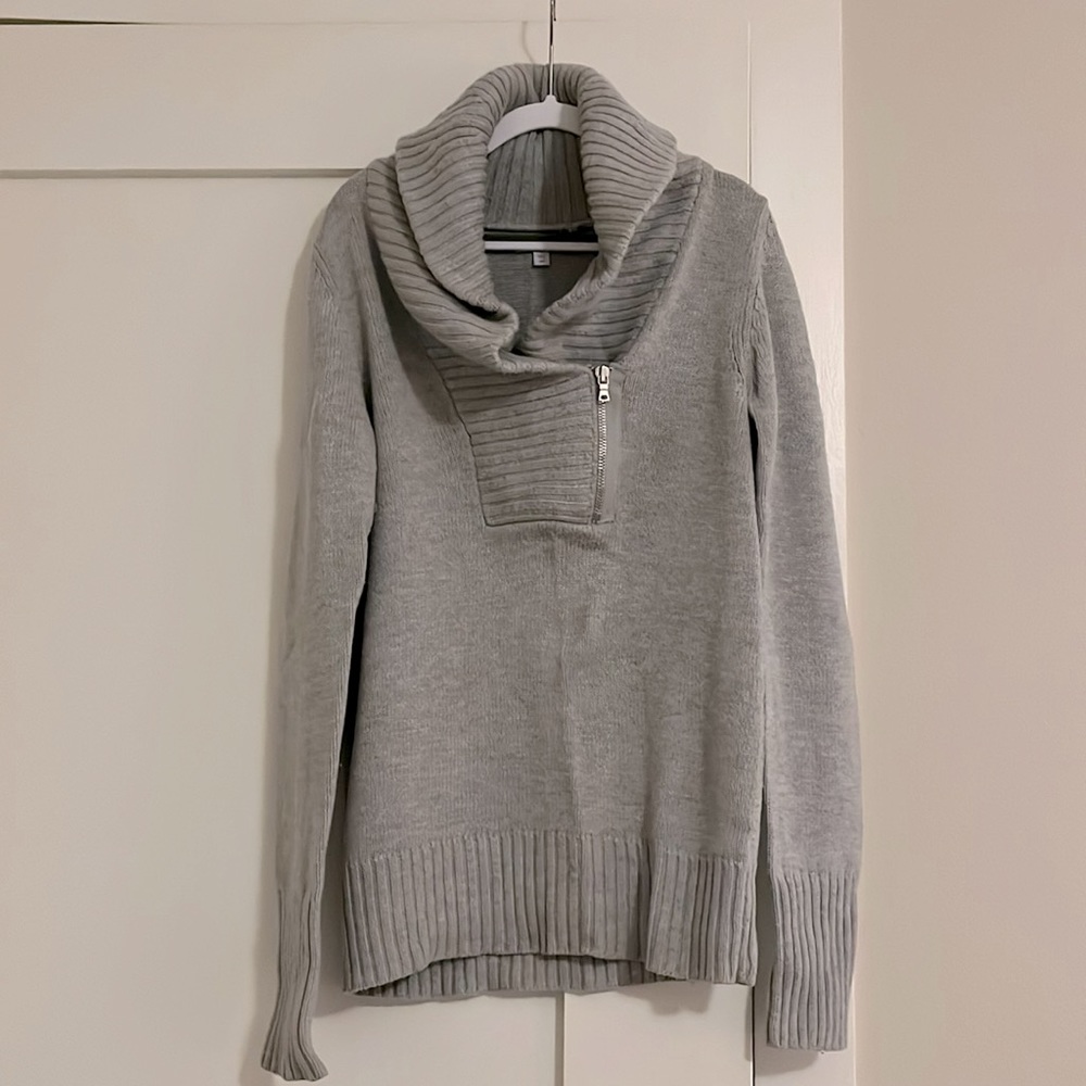 Collard fitted gray sweater with ribbed edge detail. Zip at neckline.